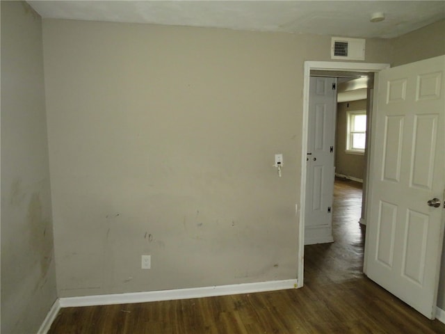 unfurnished room with dark hardwood / wood-style flooring