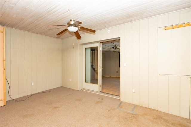 empty room featuring wood walls, carpet floors, and wood ceiling