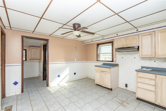 kitchen featuring ceiling fan, light brown cabinetry, and a drop ceiling