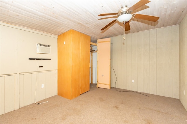 unfurnished room with a wall mounted air conditioner, light carpet, ceiling fan, and wooden walls