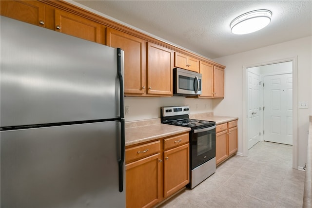 kitchen featuring a textured ceiling and appliances with stainless steel finishes