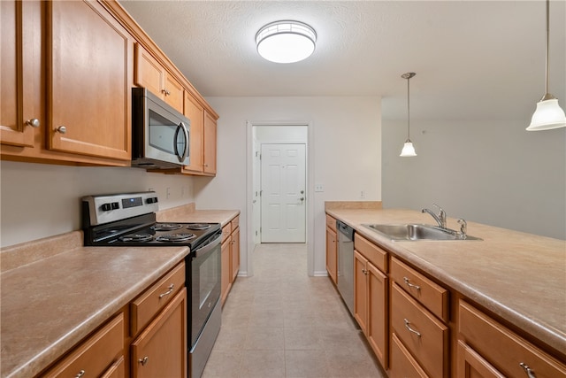 kitchen featuring pendant lighting, a textured ceiling, stainless steel appliances, and sink