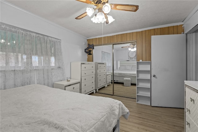 bedroom with a closet, crown molding, light wood-type flooring, a textured ceiling, and ceiling fan