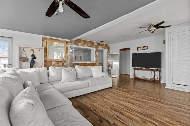 living room with wood walls, hardwood / wood-style flooring, and ceiling fan