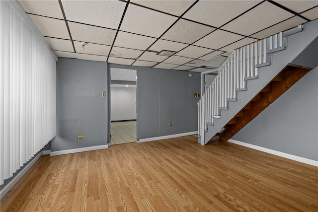 basement featuring light hardwood / wood-style floors and a paneled ceiling