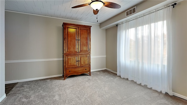 unfurnished bedroom with ornamental molding, light carpet, and ceiling fan