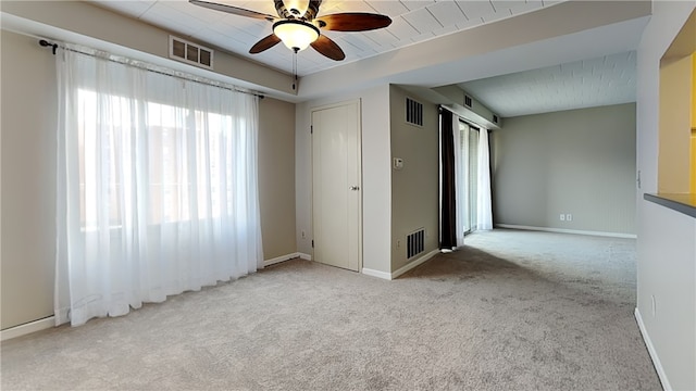 carpeted spare room featuring ceiling fan