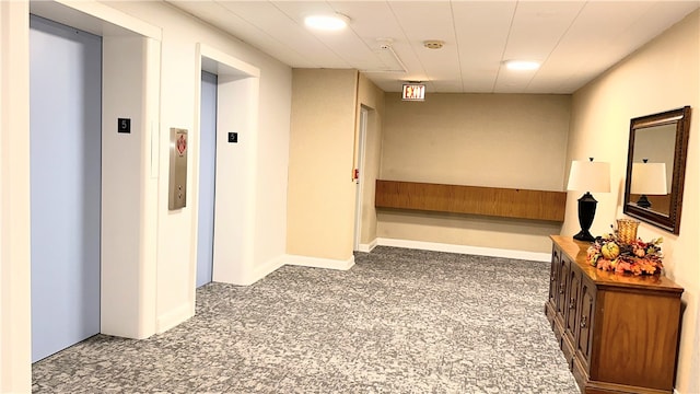 corridor featuring elevator and dark carpet