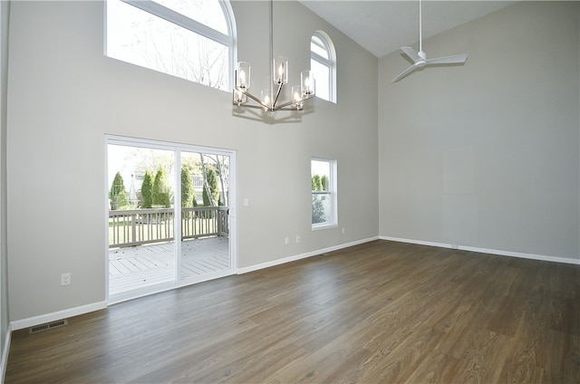 spare room with high vaulted ceiling, dark hardwood / wood-style flooring, and ceiling fan with notable chandelier