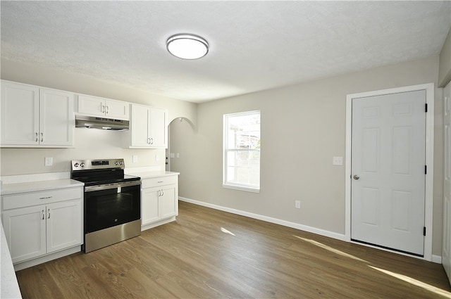 kitchen featuring white cabinets, light wood-type flooring, and electric range