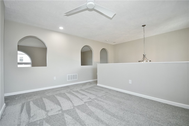 carpeted spare room with ceiling fan