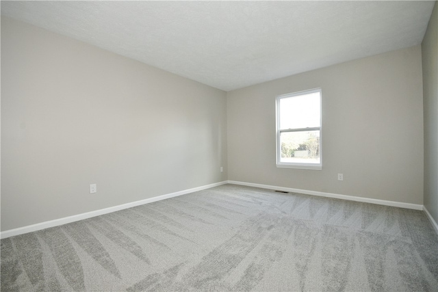 carpeted empty room featuring a textured ceiling