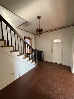 foyer entrance featuring a notable chandelier and dark hardwood / wood-style floors