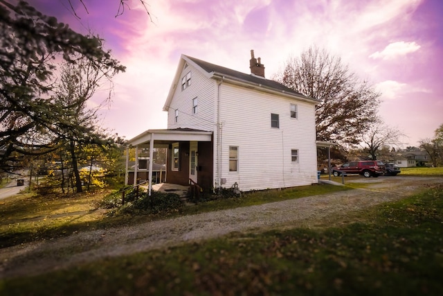 back house at dusk with covered porch