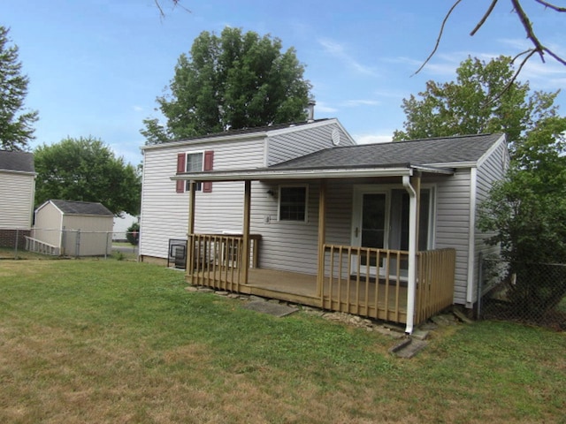 rear view of property with a lawn and a storage unit