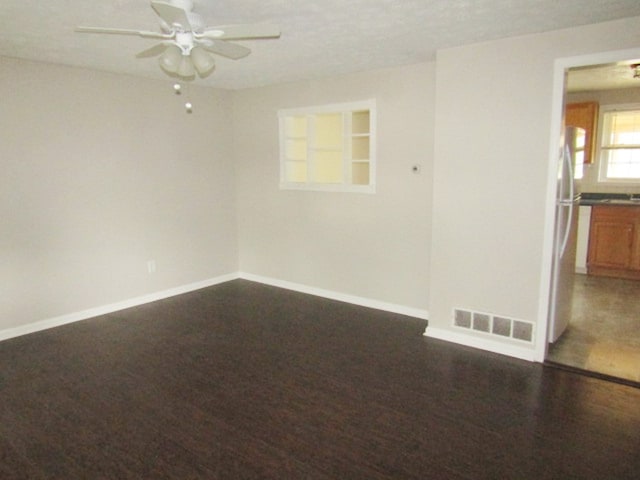 spare room featuring ceiling fan and dark hardwood / wood-style flooring