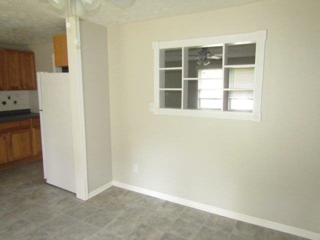 unfurnished room featuring a textured ceiling and ceiling fan