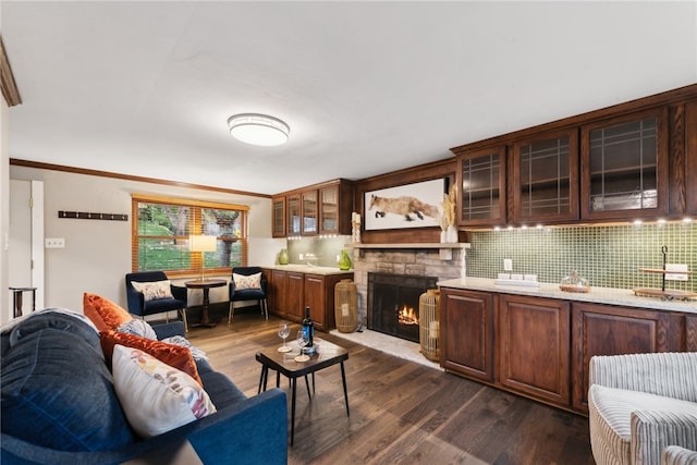 living room with a fireplace, dark hardwood / wood-style floors, and crown molding