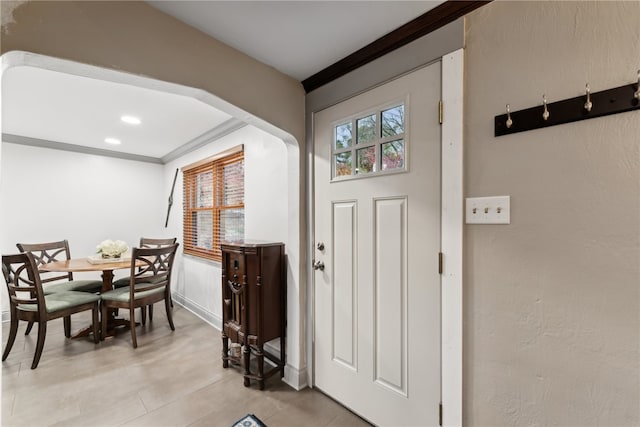 tiled foyer entrance with ornamental molding