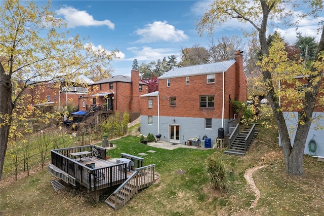 back of property with a yard and a wooden deck