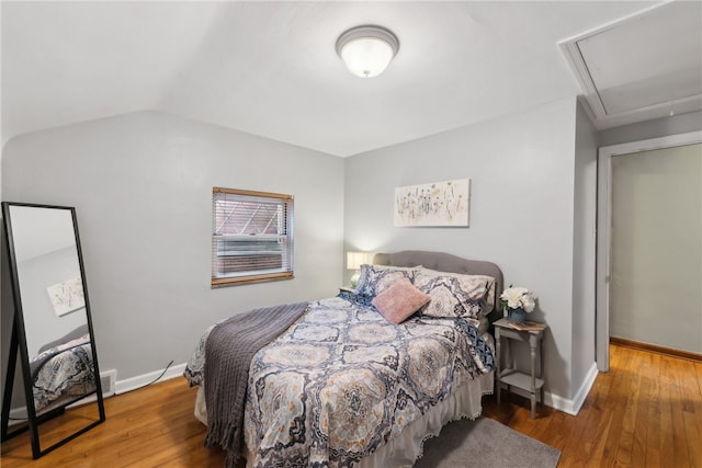 bedroom featuring hardwood / wood-style floors and vaulted ceiling