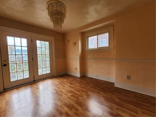 empty room featuring hardwood / wood-style floors and a chandelier