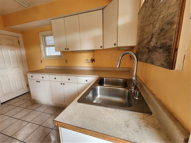 kitchen with white cabinetry, sink, and light tile patterned floors