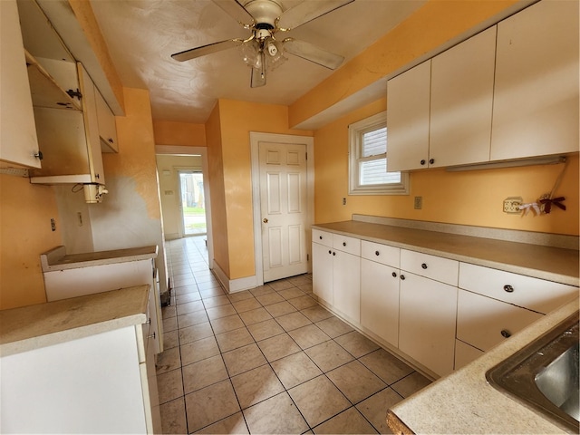 kitchen featuring light tile patterned floors, ceiling fan, and sink