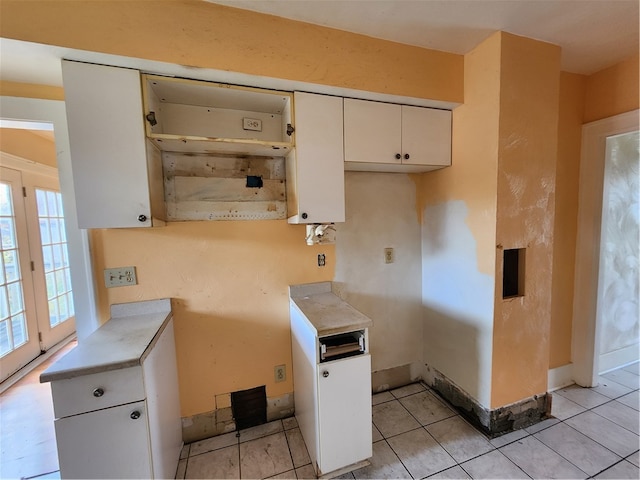 kitchen featuring white cabinets and light tile patterned flooring