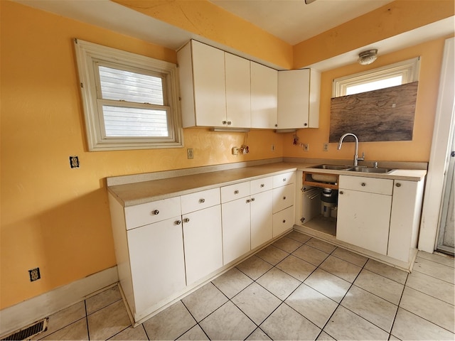 kitchen with a wealth of natural light, white cabinetry, and sink