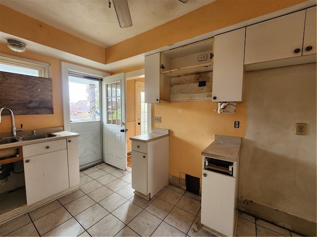 kitchen featuring white cabinets, sink, and light tile patterned flooring