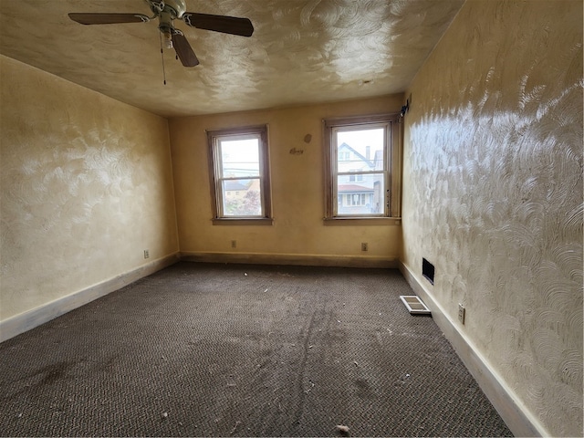 empty room with a textured ceiling, carpet floors, and ceiling fan