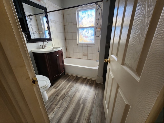 full bathroom with toilet, tiled shower / bath combo, vanity, and hardwood / wood-style flooring