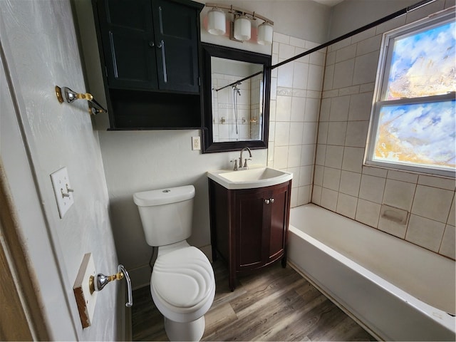 full bathroom with hardwood / wood-style floors, vanity, toilet, and tiled shower / bath