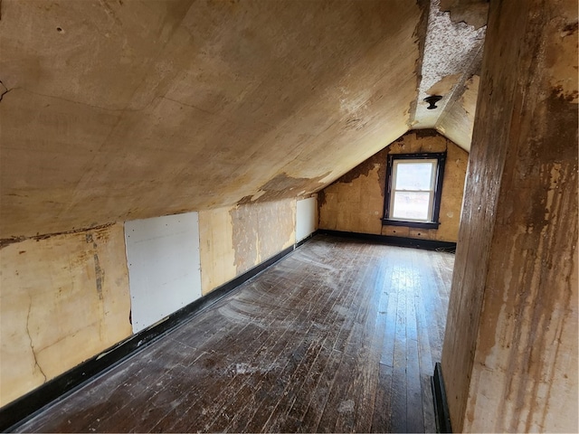 additional living space with vaulted ceiling and dark hardwood / wood-style floors