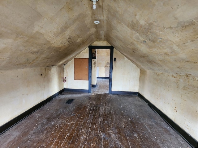 bonus room with dark hardwood / wood-style floors and vaulted ceiling