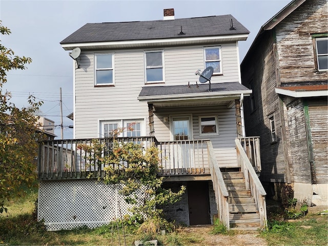 back of house with a deck