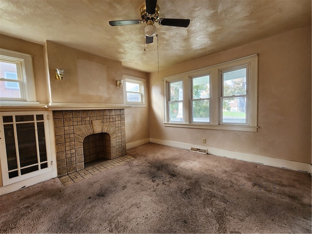 unfurnished living room featuring a fireplace, light carpet, ceiling fan, and plenty of natural light