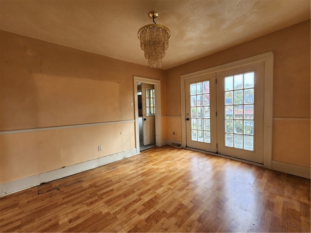 interior space featuring an inviting chandelier and light hardwood / wood-style flooring