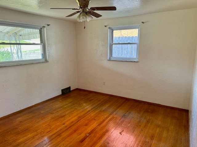 spare room with hardwood / wood-style flooring and ceiling fan