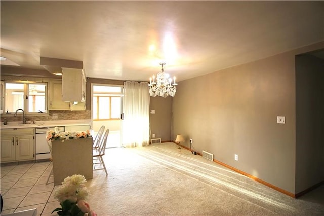 kitchen with sink, light carpet, tasteful backsplash, pendant lighting, and dishwasher