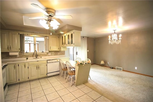 kitchen with light carpet, sink, ceiling fan with notable chandelier, white appliances, and pendant lighting