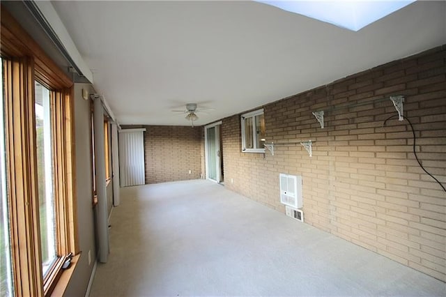219 Ball Hill Rd, German Twp, PA 15410 - carpeted empty room featuring brick wall, ceiling fan, and plenty of natural light
