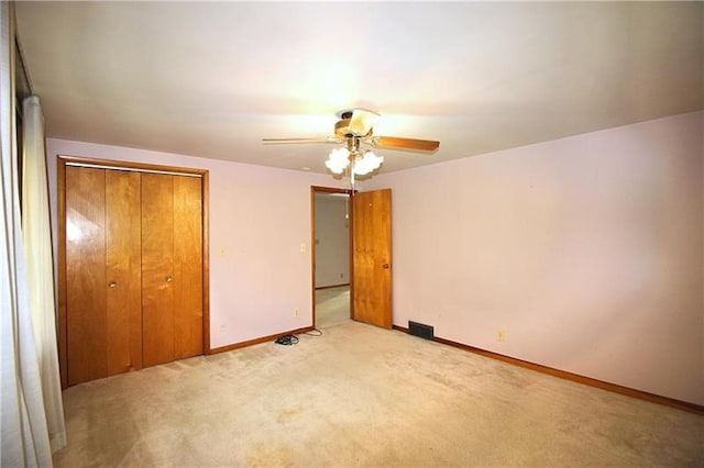 unfurnished bedroom with ceiling fan, a closet, and light colored carpet