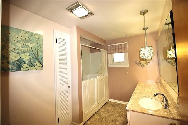 bathroom with walk in shower and vanity