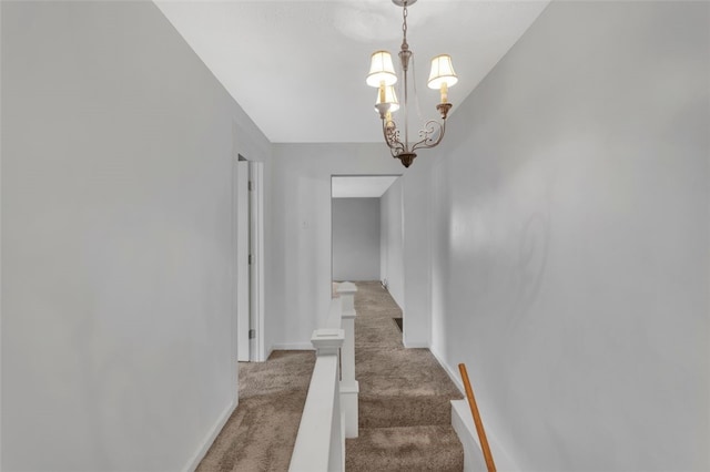 hallway with a chandelier and carpet floors