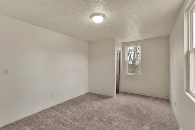 unfurnished room with a textured ceiling and carpet