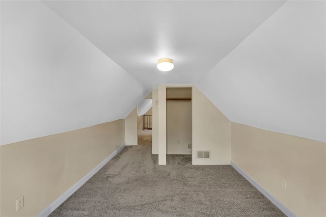 bonus room with vaulted ceiling and light colored carpet