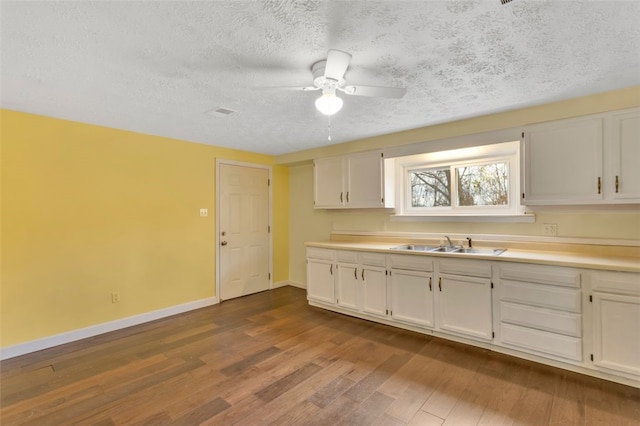 kitchen with white cabinets, hardwood / wood-style floors, and sink