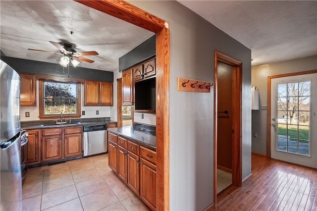 kitchen with a healthy amount of sunlight, appliances with stainless steel finishes, light hardwood / wood-style floors, and sink